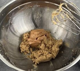 edible peanut butter cookie dough no eggs no bake, A metal mixing bowl contains cookie dough and a dollop of peanut butter with a hand mixer resting on the edge The bowl sits on a gray countertop