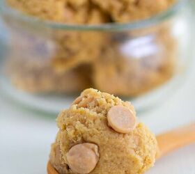 edible peanut butter cookie dough no eggs no bake, A wooden spoon holds a scoop of cookie dough with peanut butter chips with more dough and chips in a glass container in the background