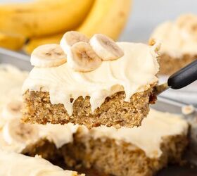 banana cake made with fresh milled flour, A spatula holds up a slice of fresh milled flour banana cake with cream cheese frosting topped with banana slices