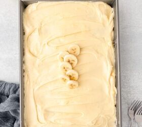banana cake made with fresh milled flour, A banana cake made in a 9X13 cake pan frosted with cream cheese frosting topped with 5 sliced banana pieces