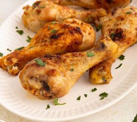 air fryer chicken legs crispy juicy and easy, A white plate with several air fryer chicken drumsticks garnished with chopped fresh parsley The chicken has a golden brown crispy exterior