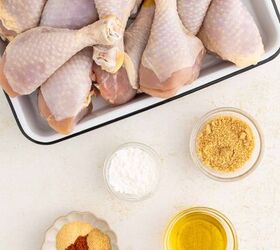 air fryer chicken legs crispy juicy and easy, A tray of raw chicken drumsticks next to small bowls containing brown sugar cornstarch spices and a bowl of olive oil on a white surface