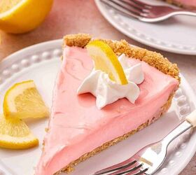 the only no bake pink lemonade pie you ll ever need, A slice of creamy no bake pink lemonade pie being lifted from a pie dish showing the graham cracker crus