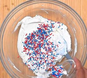easy red white and blue funfetti cake dip recipe, Red white and blue sprinkles being folded into cake dip and topped with extra sprinkles served with strawberries graham crackers and vanilla wafers for dipping