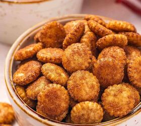 the best cinnamon sugar oyster crackers recipe, Close up of cinnamon sugar oyster crackers piled high in a small ceramic serving cup showing the glossy caramelized coating and golden toasted color of each cracker