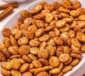 the best cinnamon sugar oyster crackers recipe, Angled shot of cinnamon sugar oyster crackers mounded on a ceramic serving platter each cracker glistening with a crispy caramelized cinnamon sugar crust on a cozy kitchen table