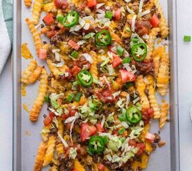 nacho fries with ground beef easy 30 minute recipe, A metal baking sheet with crinkle cut fries topped with melted cheese ground beef diced tomatoes shredded lettuce sliced jalape os and green onions creating loaded nacho fries