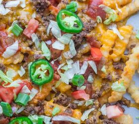 nacho fries with ground beef easy 30 minute recipe, Close up of crinkle cut fries topped with melted cheese ground beef diced tomatoes shredded lettuce green onions and sliced jalape os