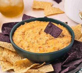 easy slow cooker hamburger velveeta dip 5 ingredients no fuss, Tortilla chip dipped into a bowl of homemade velveeta dip