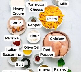 garlic parmesan pasta with chicken, Various labeled ingredients for a creamy garlic parmesan pasta with chicken are arranged on a white surface including tender chicken pasta heavy cream milk parmesan spices butter garlic flour olive oil red pepper flakes parsley and seasonings