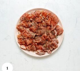 garlic parmesan pasta with chicken, Raw chicken pieces on a white plate perfectly seasoned with various spices and herbs for garlic parmesan pasta with chicken set on a light marble surface A white circle with the number 1 is in the bottom left corner