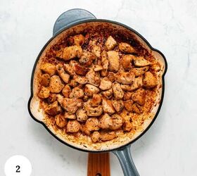 garlic parmesan pasta with chicken, A skillet filled with browned seasoned chicken pieces perfectly cooked for a garlic parmesan pasta with chicken rests on a light surface A small white circle with the number 2 is in the bottom left corner of the image