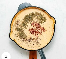 garlic parmesan pasta with chicken, A skillet of creamy garlic parmesan pasta with chicken topped with dried herbs red pepper flakes and black pepper sits on a wooden handle viewed from above on a white surface A circle with the number 3 is in the bottom left corner