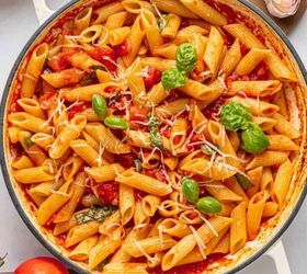 garlic parmesan pasta with chicken, A pot of Penne Pomodoro with Italian tomato sauce fresh basil leaves and grated cheese surrounded by tomatoes garlic basil and a checked cloth on a white surface a classic Italian dish