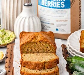 einkorn zucchini bread, Partially sliced Einkorn zucchini bread on a wooden board with fresh zucchinis and a bowl of butter