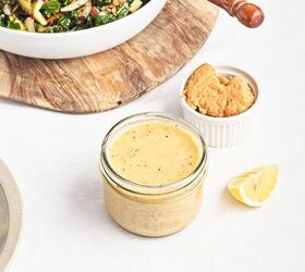 easy kale apple salad with lemon miso dressing, Creamy lemon miso dressing in a glass jar with miso paste and fresh lemon beside a kale salad