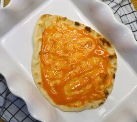 buffalo chicken pizza chicken flatbread pizza recipe, A large flatbread covered in buffalo sauce in a white baking dish
