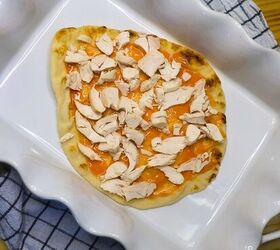 buffalo chicken pizza chicken flatbread pizza recipe, A large flatbread with buffalo sauce and shredded chicken in a white baking dish