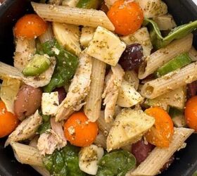 mediterranean chickpea tuna salad no mayo, A black bowl filled with chicken and pesto pasta salad penne tossed with cherry tomatoes spinach leaves mozzarella chunks olives and chicken in pesto sauce sits on a light surface