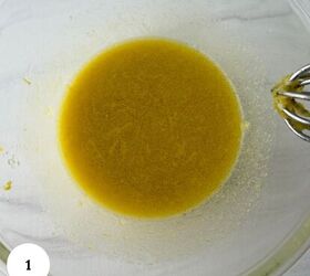 mediterranean chickpea tuna salad no mayo, A glass mixing bowl with a yellowish liquid mixture and a metal whisk seen from above perfect for prepping ingredients like those in a chickpea tuna salad The number 1 is in a white circle in the bottom left corner