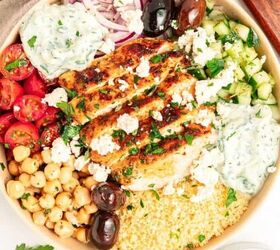 mediterranean chickpea tuna salad no mayo, A Mediterranean bowl filled with grilled chicken couscous cherry tomatoes chickpeas cucumber kalamata olives red onion tzatziki sauce and crumbled feta cheese surrounded by bowls of olives and tomatoes