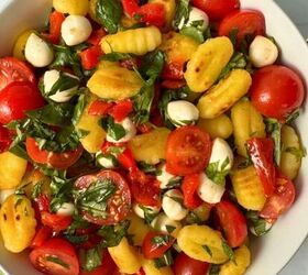 mediterranean chickpea tuna salad no mayo, A bowl of gluten free gnocchi salad with cherry tomatoes mozzarella balls red bell pepper and fresh basil sits on a light surface accompanied by a spoon and green napkin