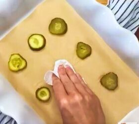 two ingredient fried pickles baked cheddar pickle crisps recipe, A hand drying pickle slices with a paper towel