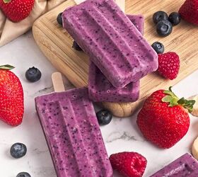 easy banana bread using yellow cake mix recipe, Triple berry smoothie popsicles stacked on a wooden board with fresh strawberries blueberries and raspberries