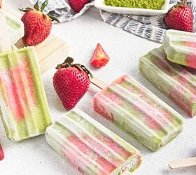 homemade matcha popsicles with strawberry layers, Homemade matcha strawberry popsicles arranged on a white surface with fresh strawberries
