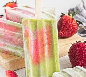 homemade matcha popsicles with strawberry layers, Upright matcha popsicle with strawberry layers surrounded by fresh strawberries and frozen popsicles