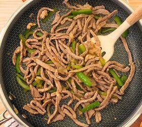 philly cheesesteak sliders easy cheesesteak slider recipe, Cooked thin sliced steak with onions and peppers in a skillet