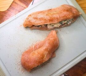 air fryer stuffed chicken spinach cream cheese stuffed chicken, Two stuffed chicken breasts seasoned on a cutting board
