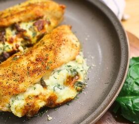 air fryer stuffed chicken spinach cream cheese stuffed chicken, Close up image of two air fryer stuffed chicken breasts on a plate