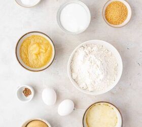 moist applesauce muffins, Bowls on a countertop containing baking ingredients flour eggs applesauce brown sugar granulated sugar melted butter cinnamon ginger milk salt and vanilla extract all arranged neatly