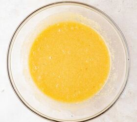 moist applesauce muffins, A clear glass bowl containing a smooth yellow batter sits on a light colored textured surface