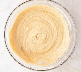 moist applesauce muffins, A glass mixing bowl filled with smooth light beige cake batter sits on a light colored marble surface The batter has been mixed into a creamy swirled texture