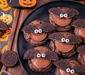 oreo bat cookies made with cake mix and reese s cups, Close up of Oreo bat cookies topped with Reese s peanut butter cups and candy eyes on a Halloween dessert table