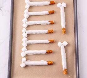 rice krispie turkey leg treats using pretzel bones, Dipped pretzel rods with mini marshmallows on a lined baking sheet